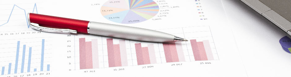 A pen laying on printed financial reports.